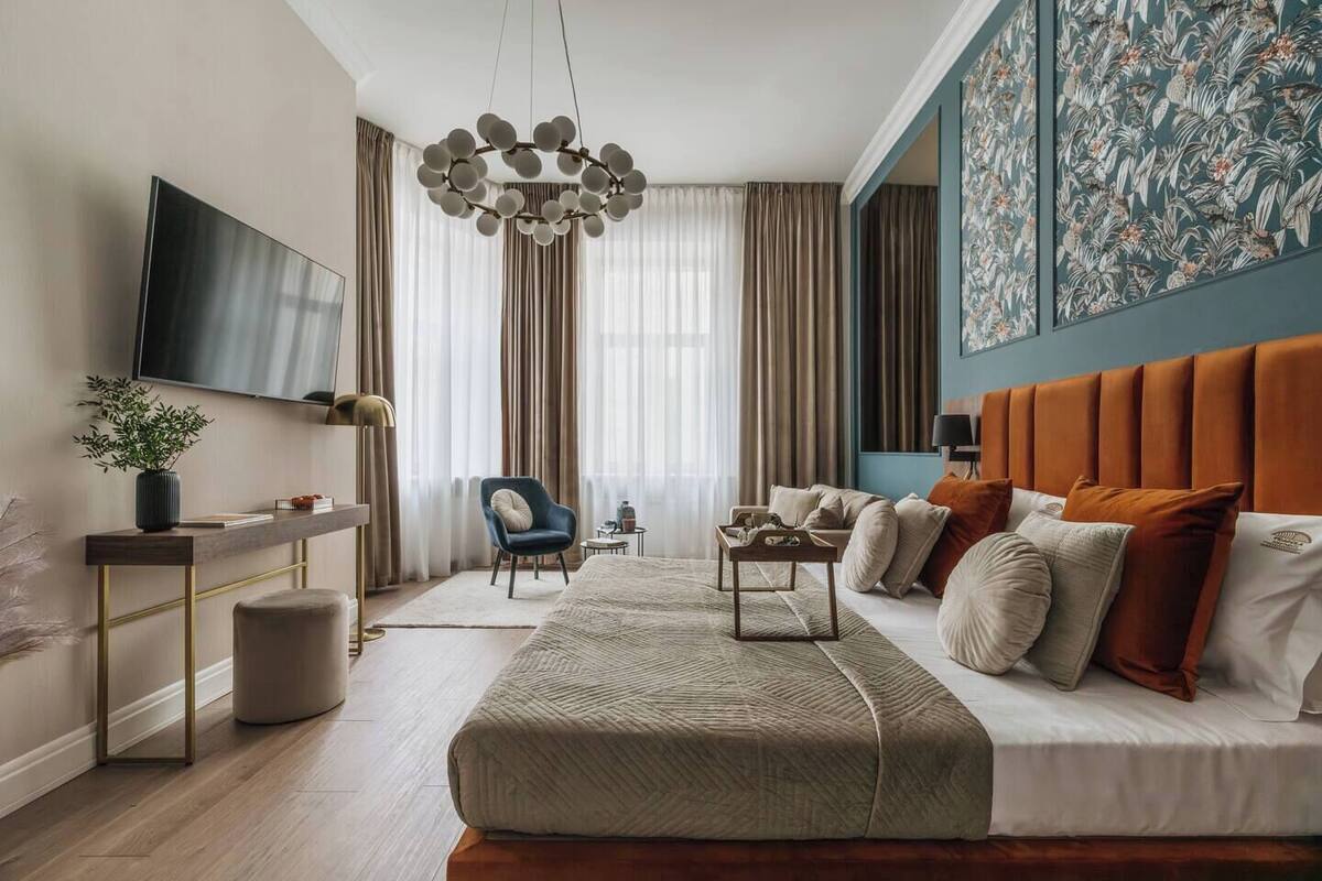 Un dormitorio moderno con una cama grande, un televisor, un escritorio y una silla.