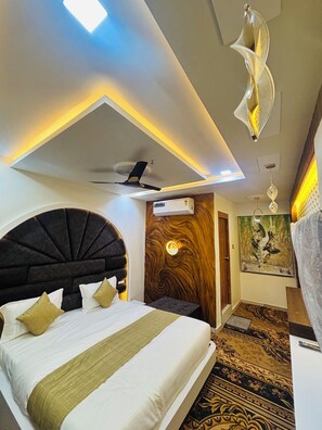 Ein modernes Hotelzimmer mit einem großen Bett, einem Deckenventilator und einer wandmontierten Klimaanlage.