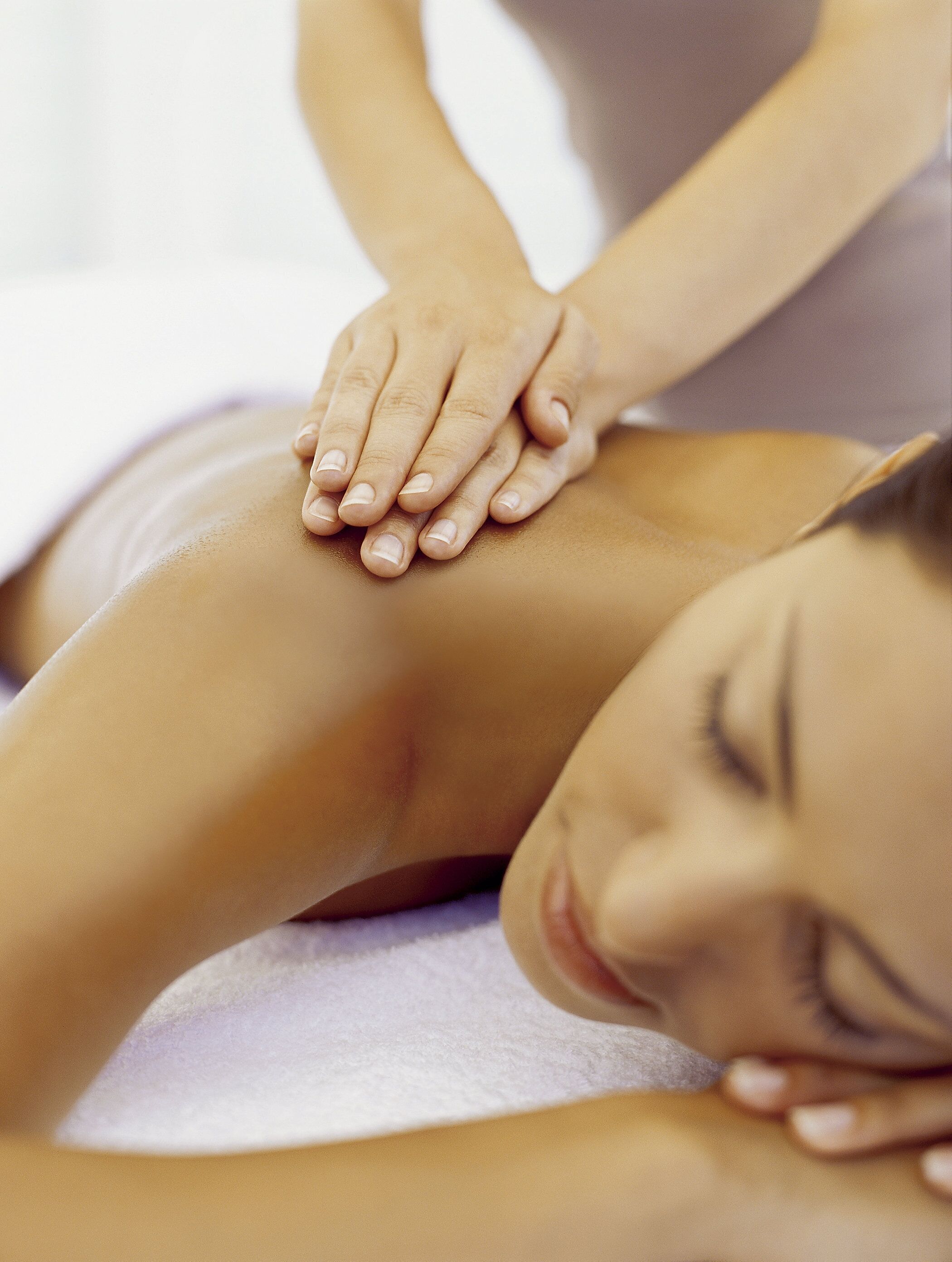 A close-up of a massage session with a focus on hands and a person's leg.