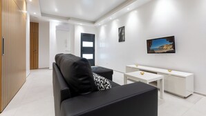 A modern living room with a black sofa, a white coffee table, and a white cabinet. - Correeira Luxury Residence E (Albufeira)