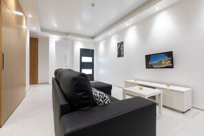 Ein modernes Wohnzimmer mit einem schwarzen Sofa, einem weißen Couchtisch und einer weißen Kommode.