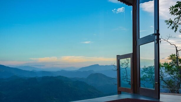 A room with a large glass door leading to a mountain view. - The Cloud Resort (Kadugannawa)