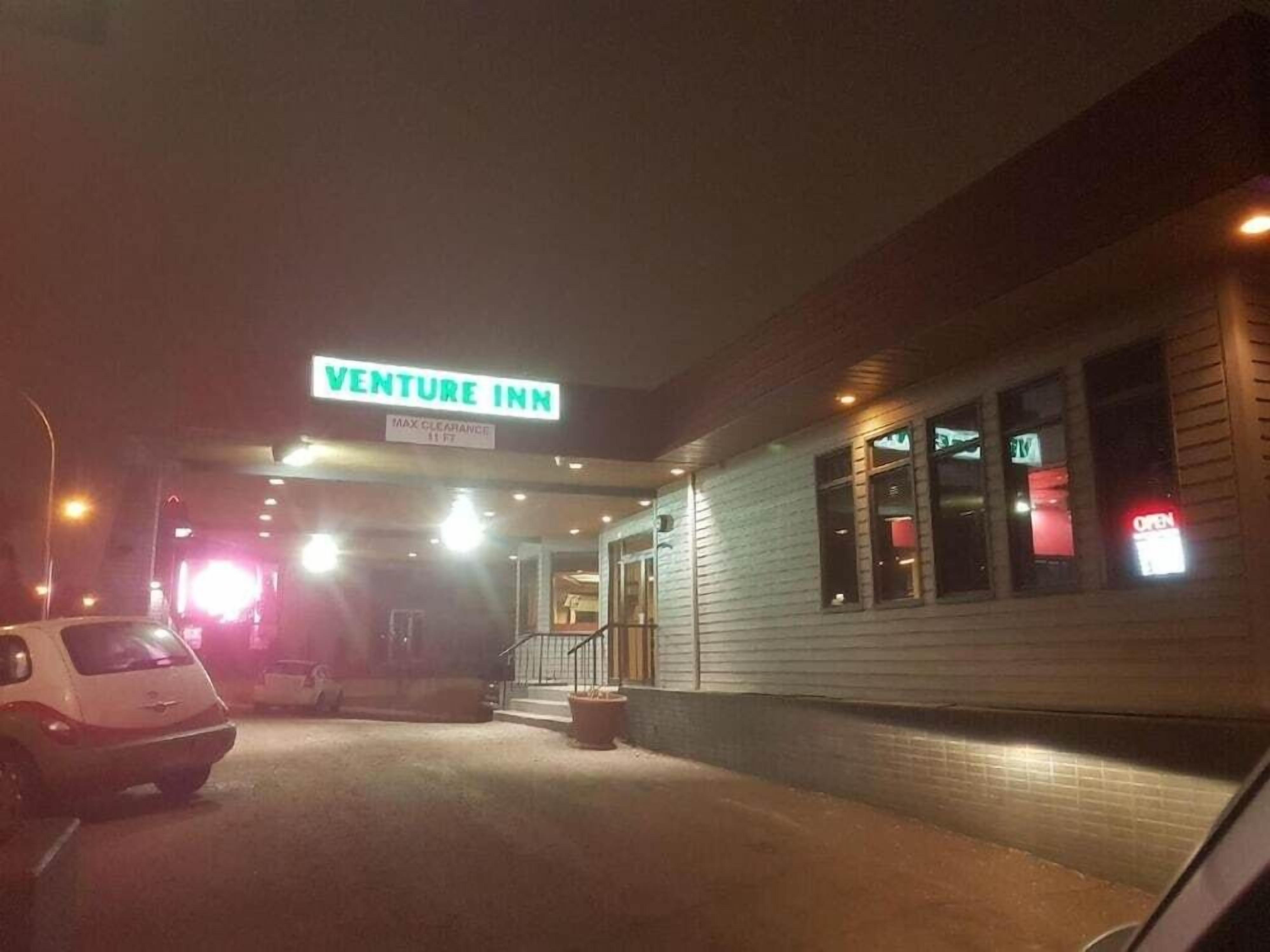 The exterior of the Venture Inn with a sign indicating a maximum clearance of 11 ft.
