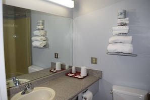 A bathroom with a sink, mirror, towel rack, and toilet.