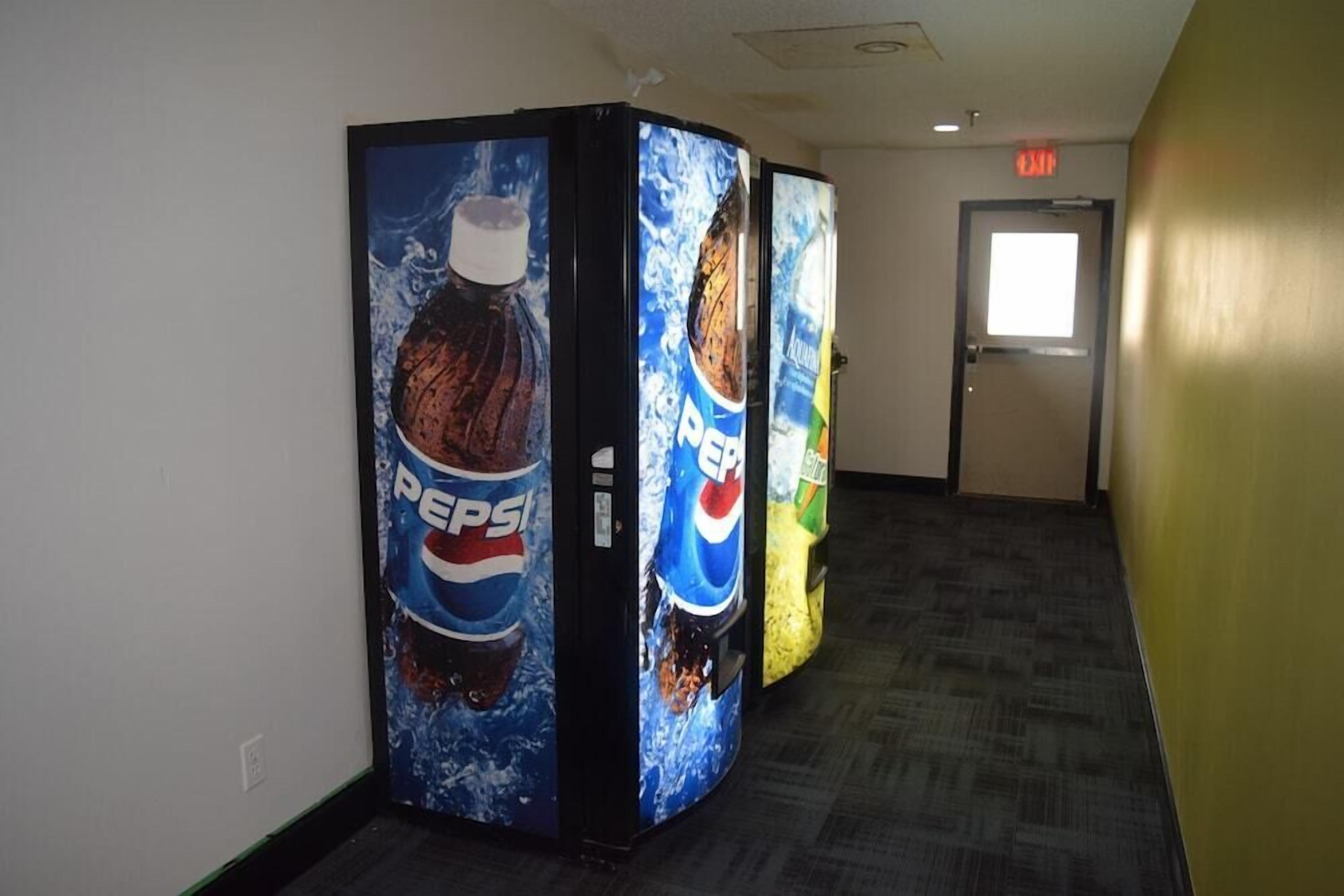 A hallway with vending machines displaying Pepsi advertisements.
