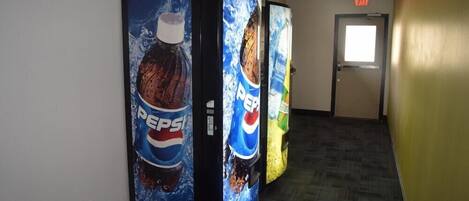 A hallway with vending machines displaying Pepsi advertisements.