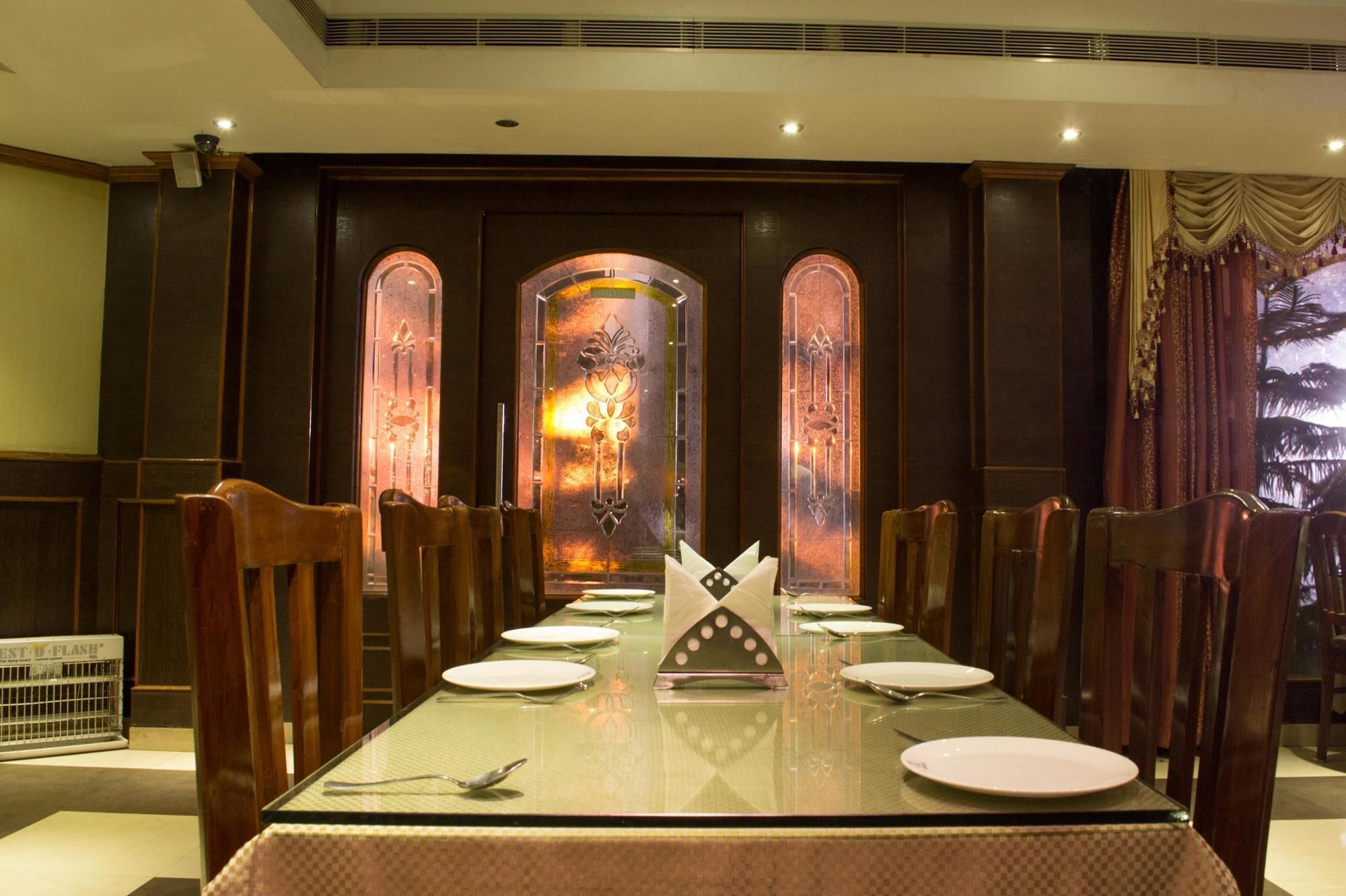 A dining area with a long table set for six, surrounded by wooden chairs.