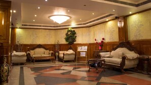 A lobby with two sofas, a coffee table, a chandelier, and a decorative plant. - OYO Premium Nayapalli IRC Village (Bhubaneshwar)