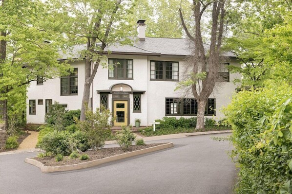 A two-story house with a front entrance, a small porch, and a driveway.