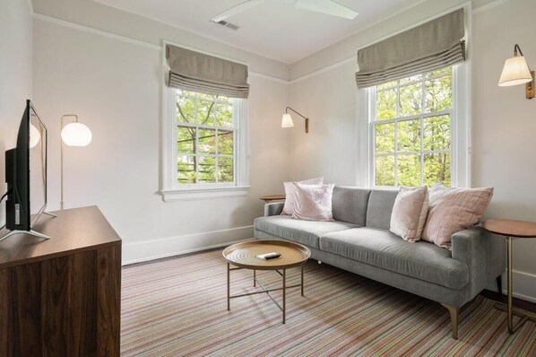 A living room with a sofa, a coffee table, and a TV stand.