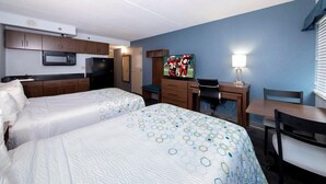 A hotel room with two beds, a kitchenette, a desk with a computer, a TV, and a window with blinds. - Extended Stay America - Washington DC - Chantilly (Chantilly)