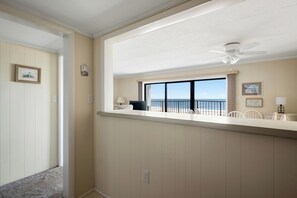 A room with a balcony overlooking the ocean, a ceiling fan, and a view of the sea. - Oceanfront Escape on 132nd Street (Ocean City)