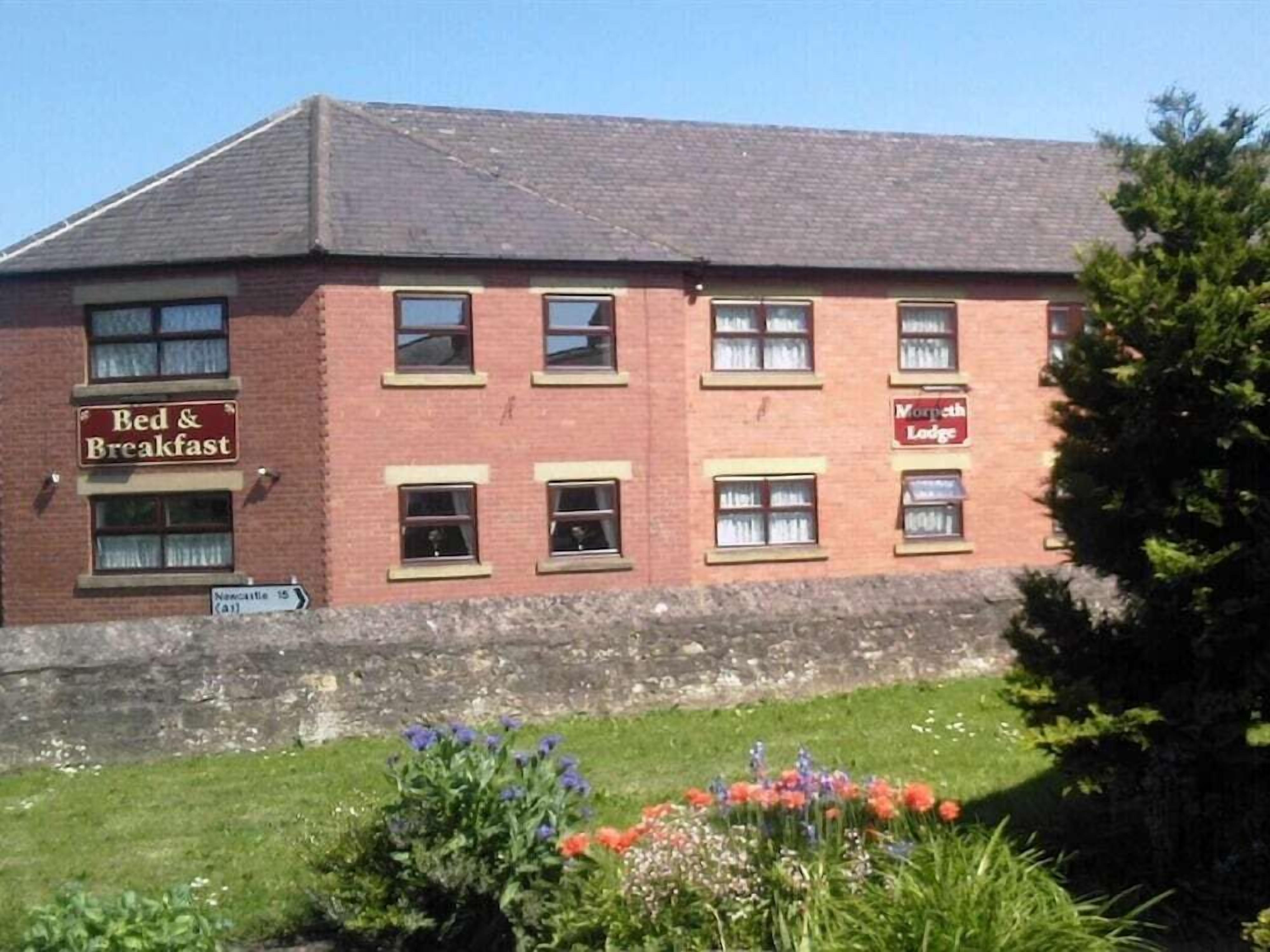 A red brick building with a sign for 'Bed & Breakfast' and 'Morpeth Lodge'.