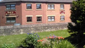 A red brick building with a sign for 'Bed & Breakfast' and 'Morpeth Lodge'. - Morpeth Lodge (Morpeth)