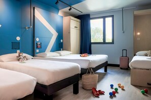 A hotel room with two beds, a large mirror, a wardrobe, a window with curtains, and a suitcase. - Ibis Budget La Rochelle Centre (La Rochelle)