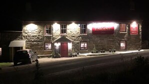 Ein Steinhaus mit einem roten Schild, auf dem „ENGINE Inn“ steht.