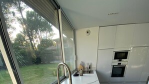 Una cocina moderna con un ventanal grande, un fregadero y un horno.