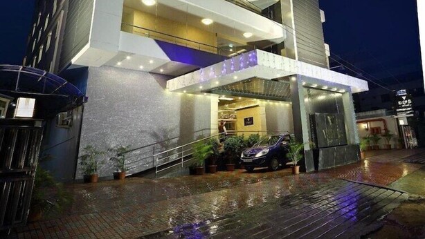 A modern hotel with a multi-story structure, a covered entrance, and a visible car parked outside. - Keys Hotel Vihas (Tirupati)