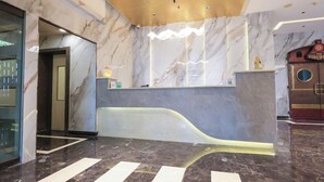 A reception area with marble walls, a reception desk, and a train-themed decor element. - Keys Hotel Vihas (Tirupati)