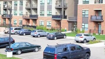 Un immeuble résidentiel à plusieurs étages avec un parking situé à l’avant.