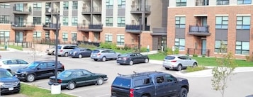 Un edificio residencial de varios pisos con un estacionamiento al frente.