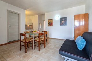 Ein kompakter Wohnbereich mit Essplatz, Küchenzeile und einer Couch.