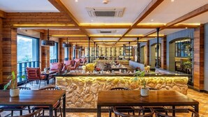 A restaurant with wooden beams, stone walls, and a bar area. - Antalya By Divine Ganga Cottage (Narendranagar)