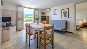 A compact living space with a dining area, kitchenette, and a sofa. - Apartment 'Villa Singola 3' with Mountain View, Wi-Fi and Air Conditioning (La Muddizza)