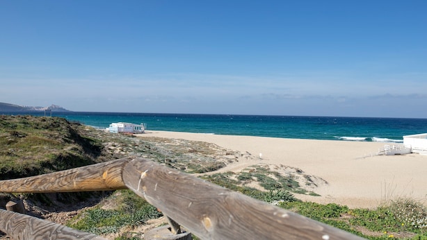 A beach with a wooden fence, sandy shore, and a building in the background. - Apartment 'Villa Singola 2 Sea View' with Private Terrace and Air Conditioning (La Muddizza)