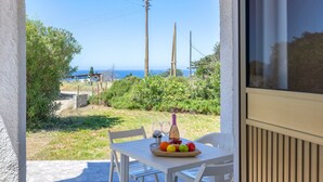 A patio with a table set for two, a bottle, and a fruit bowl. - Apartment 'Villa Singola 2 Sea View' with Private Terrace and Air Conditioning (La Muddizza)