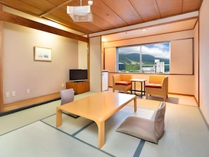 Una stanza tradizionale in stile giapponese con pavimento in tatami, un tavolino e sedute.