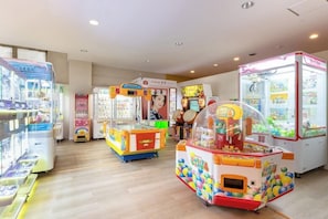 Eine Reihe von hell beleuchteten Spielautomaten in einem Raum mit Holzboden und weißer Decke.