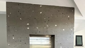 An elevator with a speckled gray wall, a blue accessibility sign, and a small window on the right. - 2bedroom beachfront Apartmnt Mombasa,Seaview,Ac,pool,gym,restaurant,beach access (Mombasa)