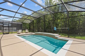 A covered outdoor swimming pool with a glass enclosure, surrounded by a deck with lounge chairs. - 4 Bed Close to Disney Private Pool (Kissimmee)