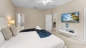 A bedroom with a bed, a ceiling fan, a TV, and a door leading to another room. - 4 Bed Close to Disney Private Pool (Kissimmee)