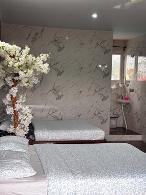 A bedroom with a marble-patterned wall, a large window, and a bedside table with a mirror. - Nature's Resort (Sidlaghatta)