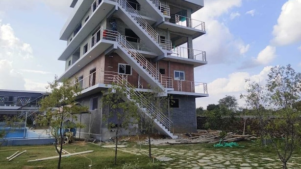 A multi-story building with a modern architectural design, featuring balconies and staircases. - Nature's Resort (Sidlaghatta)