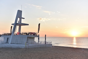 A beachside structure with a viewing platform, a flag, and a signboard. - Forest Beach Hotel (Kiten)