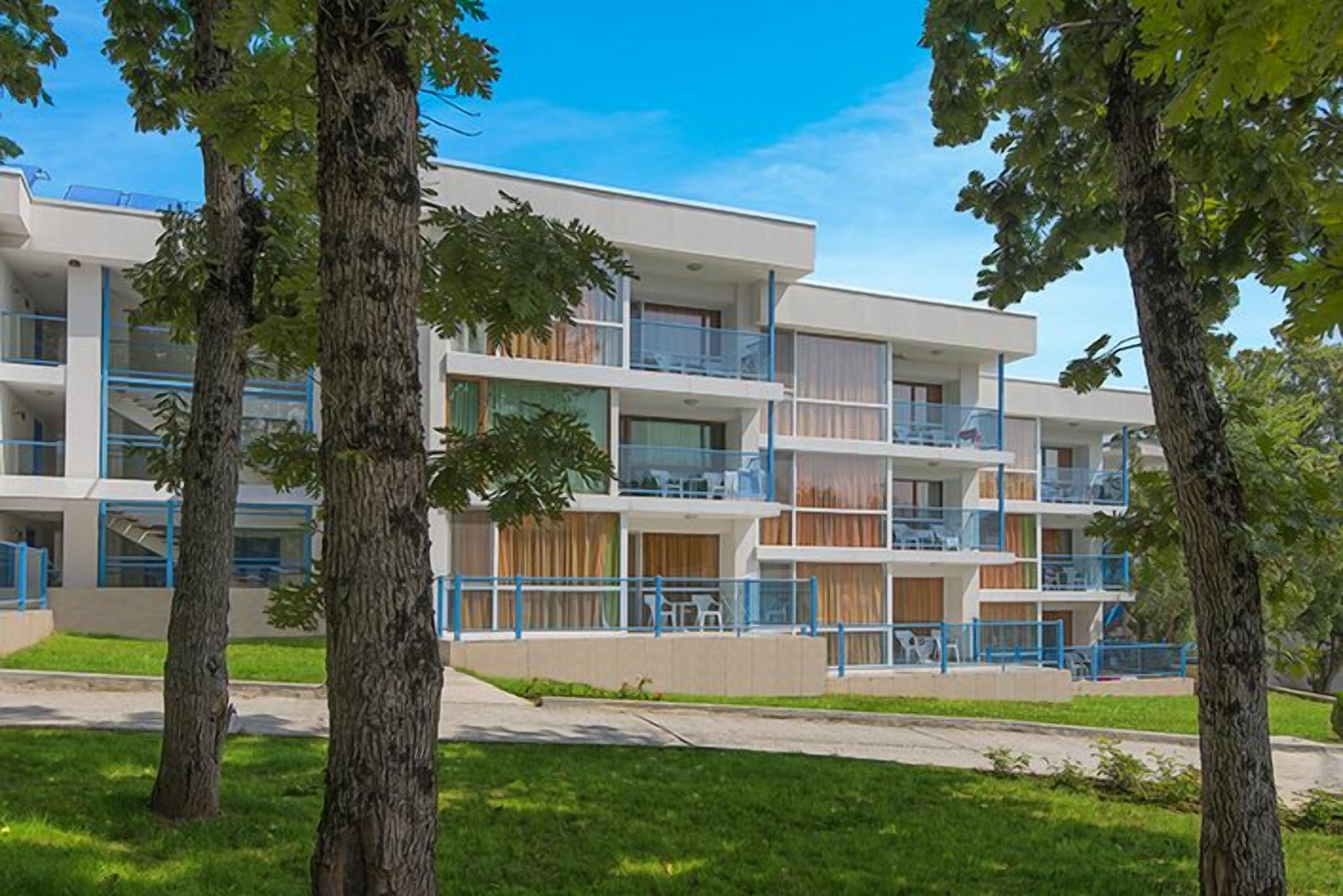 A multi-story hotel with balconies, a flat roof, and a modern design.