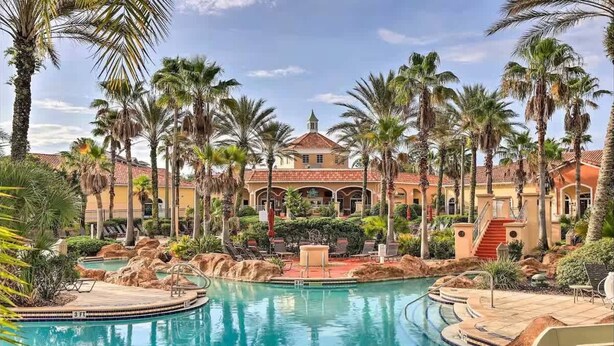 A resort with a central pool, palm trees, and a building with a red roof. - Tranquil Townhouse 3 bed Lazy River Resort (Davenport)