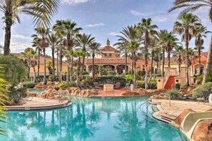 A resort with a central pool, palm trees, and a building with a red roof. - Tranquil Townhouse 3 bed Lazy River Resort (Davenport)