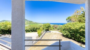 A coastal view from a balcony with a clear sky and distant sea. - Apartment 'Con Terrazza' with Sea View, Wi-Fi and Air Conditioning (Valledoria)