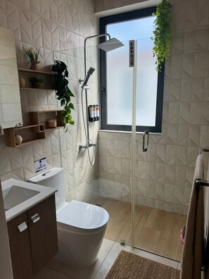 A modern bathroom with a freestanding bathtub, a glass-enclosed shower, and a window with a view. - NOK Modern 3BR Villa With Patio by Vistacana (Punta Cana)