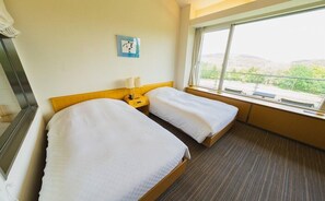 A hotel room with two single beds, a nightstand with a lamp, a wall clock, and a large window offering a view of greenery and hills. - Furano Hotel (Furano)