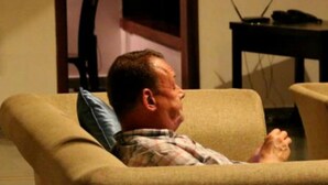 A person sitting on a beige armchair in a room with a wooden table and a laptop. - Aveda Kumarakom (Kottayam)