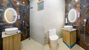 A modern bathroom with two sinks, marble walls, and a toilet. - Hotel Silver Star (Greater Noida)