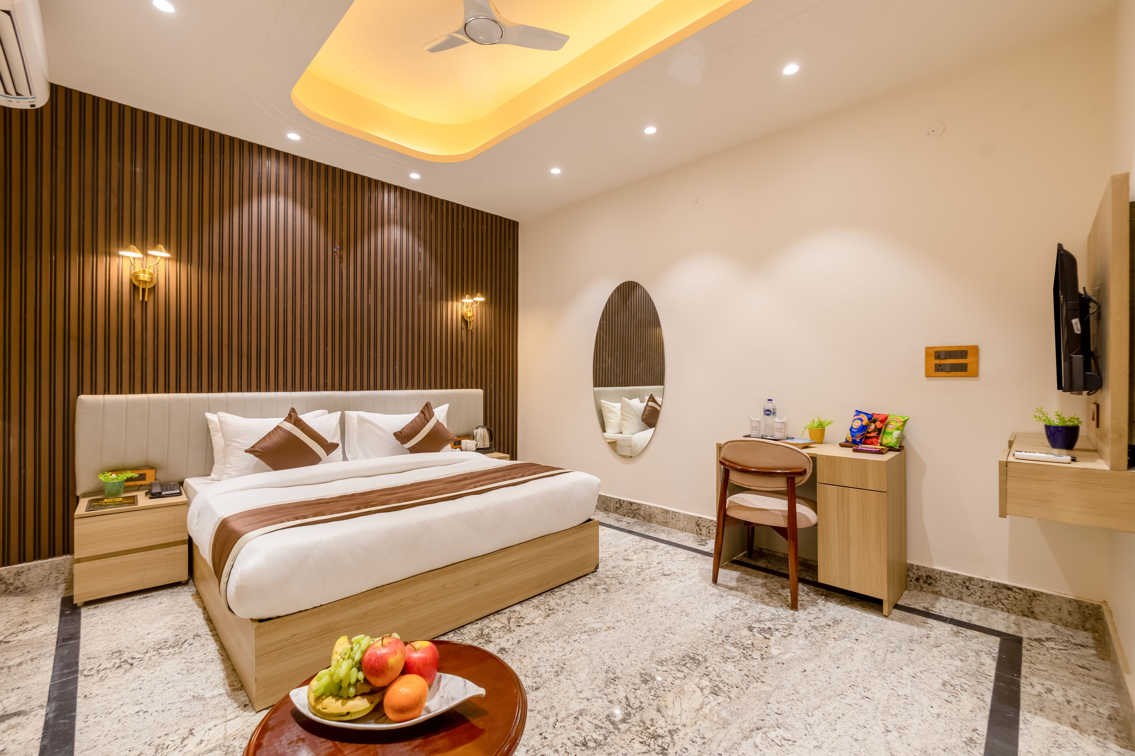 A modern hotel room with a large bed, bedside tables, a desk, and a chair.