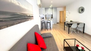 Un espacio habitable moderno con cocina, comedor y un amplio ventanal con vista al mar.