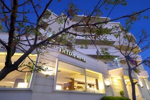 Un hotel de varios pisos con una fachada moderna, amplias ventanas y una entrada destacada.