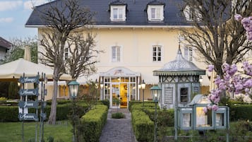 Ein Gebäude mit Café und Restaurant, einem Kopfsteinpflasterweg und einem kleinen Pavillon.